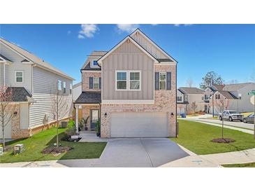 Beautiful two-story home featuring a brick and siding exterior and an attached two-car garage at 1566 Winding Ridge Trl, Hoschton, GA 30548