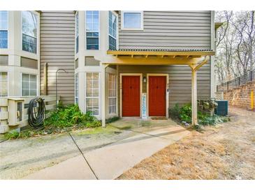 Townhouse exterior featuring a sidewalk leading to two red front doors under a shared, covered entrance at 808 Riverview Se Dr, Marietta, GA 30067