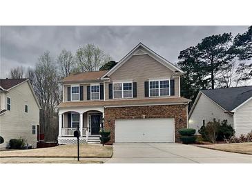 Charming two-story home featuring a brick and siding exterior, complemented by a well-maintained front yard and two-car garage at 634 Sandpiper Cv, Stockbridge, GA 30281