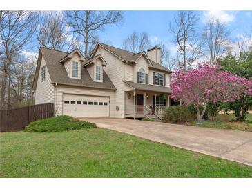 Charming two-story home with a manicured lawn, flowering tree, and an attached two-car garage at 7810 Rose Ct, Cumming, GA 30040