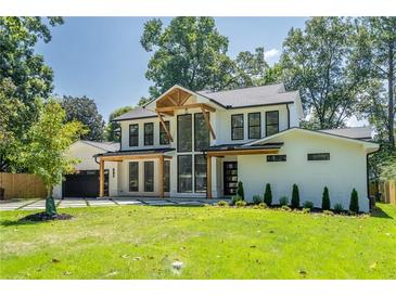 Stunning two-story home with a modern design, lush lawn, and eye-catching natural wood elements at 1653 Pamela Ne Dr, Brookhaven, GA 30319
