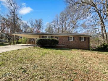 Charming single-story brick home featuring a covered carport, providing convenient parking and protection from the elements at 3686 Sweetbriar Cir, Lithia Springs, GA 30122