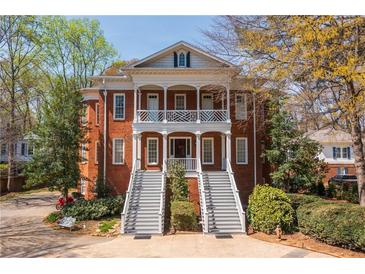 Stately brick home featuring dual staircases, charming balconies, and mature landscaping at 3847 Sweet Bottom Dr, Duluth, GA 30096