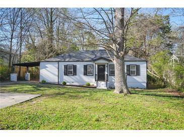 Charming single-story home featuring a manicured lawn, carport, and classic architectural details at 1013 Columbia Dr, Decatur, GA 30030
