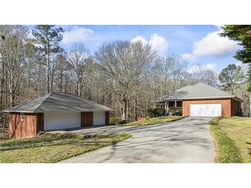 A red brick house and detached two-car garage on a large lot at 5595 Rolling Acres Ln, Cumming, GA 30028