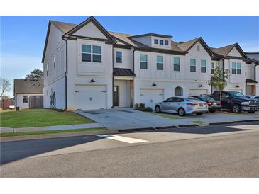 Beautiful townhome with a traditional white brick exterior and attached garages at 76 Auburn Run Ln, Auburn, GA 30011