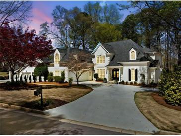 Stunning two-story home with a circular driveway and lush landscaping at 302 W Country Dr, Johns Creek, GA 30097