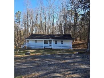 Charming single-story home featuring a welcoming front porch and surrounded by mature trees at 1610 Mulberry Rock Rd, Dallas, GA 30157