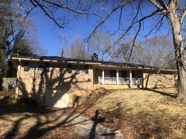Charming brick ranch-style home featuring a cozy front porch and attached garage at 1731 Dogwood Trl, Douglasville, GA 30134