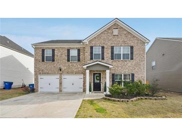 Charming two-story brick home with attached two-car garage and well-maintained front yard at 3464 Enterkin Ln, Atlanta, GA 30349