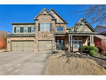 Charming two-story home with stone accents, a two-car garage, and a well-manicured lawn at 4540 Hastings Dr, Cumming, GA 30041