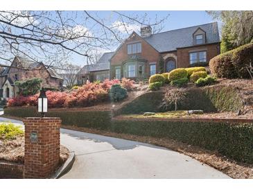 Stunning brick home featuring mature landscaping and a manicured lawn with a private drive at 46 Montclair Ne Dr, Atlanta, GA 30309