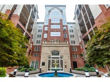 Elegant brick condominium building featuring a central water fountain and manicured landscaping at 50 Biscayne Nw Dr # 6111, Atlanta, GA 30309