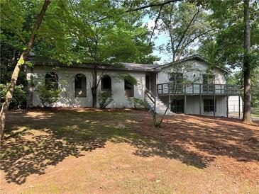 Charming white brick home featuring a spacious front yard and a deck perfect for outdoor relaxation at 5384 Blackhawk Dr, Acworth, GA 30102