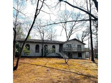 Charming single-story home with a deck and ample yard space surrounded by mature trees at 5384 Blackhawk Dr, Acworth, GA 30102