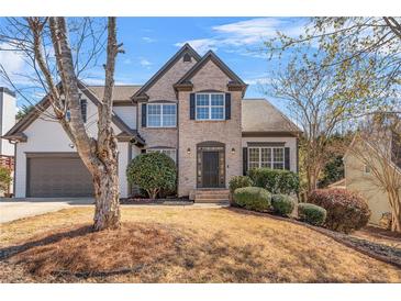 Charming two-story brick home featuring a well-maintained lawn and an attached two-car garage at 1047 Panoramic Pointe, Buford, GA 30518