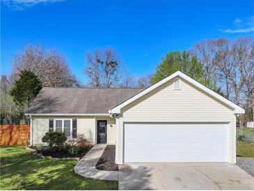 Charming single-story home with manicured lawn, attached garage and welcoming curb appeal at 7750 Silversmith Dr, Cumming, GA 30028