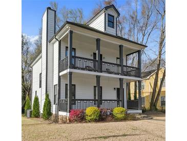 Charming two-story home with a double porch, offering curb appeal and outdoor living space at 1450 Donald Lee Hollowell Nw Pkwy, Atlanta, GA 30318