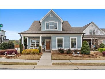 Charming home with blue siding, a covered porch with seating, and well-maintained landscaping at 200 Oakside Way, Lawrenceville, GA 30046