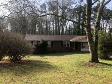 Charming brick ranch-style home with a well-maintained lawn and mature trees providing shade at 2076 Dobbins Nw Dr, Kennesaw, GA 30144