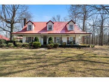 Charming home features a red roof, dormer windows, and a welcoming front porch surrounded by mature landscaping at 680 Milligan Creek Rd, Roopville, GA 30170