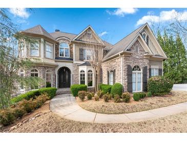 Beautiful two-story home with stone and siding exterior, manicured landscaping, and inviting curb appeal at 8069 Kenstone Ct, Sandy Springs, GA 30350