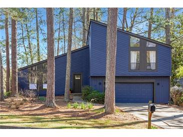 Charming contemporary home with beautiful blue siding and an attached two-car garage at 210 Trailmore Ct, Roswell, GA 30076