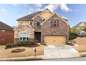 Charming two-story home featuring a stone and brick facade with well-manicured landscaping at 5877 Stow Dr, Tucker, GA 30084