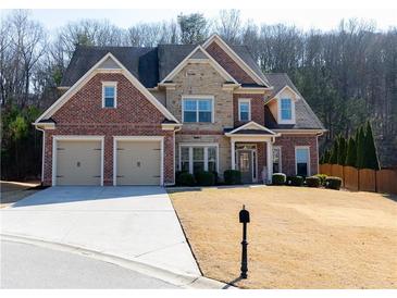 Beautiful two-story home with a brick and stone facade and well-manicured lawn at 1960 Overlook Springs Ln, Cumming, GA 30040