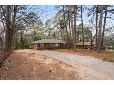 Ranch home with brick facade and long driveway surrounded by mature trees at 5273 Crystal Ln, Atlanta, GA 30349