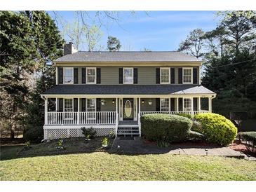 Charming two-story home features a welcoming front porch and beautifully landscaped front yard at 1472 Hartman Sw Dr, Lilburn, GA 30047