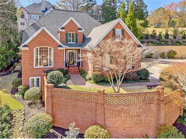 Beautiful brick home featuring manicured landscaping, a charming walkway, and arched windows offering an inviting curb appeal at 4732 Corina Ne Pl, Roswell, GA 30075