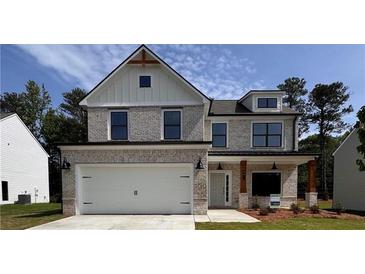 Charming two-story home featuring a brick facade, a two-car garage, and a covered front porch with wooden columns at 376 Waterbluff Dr, Mableton, GA 30126