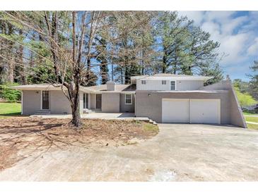 Charming single-story home features a two-car garage and gray brick exterior at 1507 Fair Haven Dr, Riverdale, GA 30296