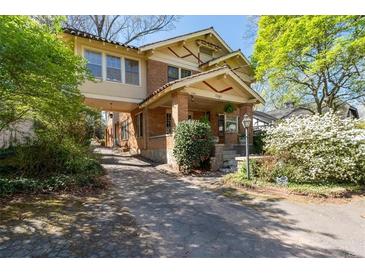 Charming two-story brick home featuring a covered walkway and beautifully landscaped front yard at 2265 E Lake Ne Rd, Atlanta, GA 30307
