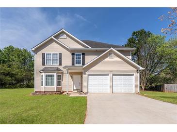 Charming two-story home featuring a well-maintained lawn, attached two-car garage, and classic siding at 2485 Field Spring Dr, Stonecrest, GA 30058