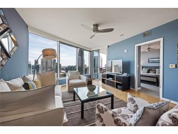 Bright living room features expansive city views, hardwood floors, and comfortable seating with stylish decor at 3338 Peachtree Ne Rd # 2804, Atlanta, GA 30326