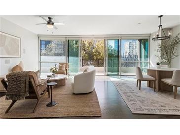Bright living room boasts floor-to-ceiling windows, modern furnishings, and an open layout at 700 Park Regency Ne Pl # 803, Atlanta, GA 30326