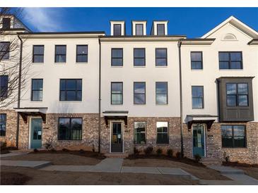 Modern townhome featuring painted brick facade and dark-trimmed windows, offering contemporary curb appeal at 5450 Howington Ct # 195, Buford, GA 30518