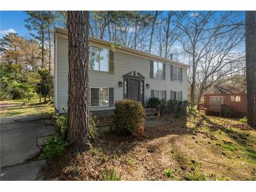 Charming two-story home with a tidy front yard and mature tree on a sunny day at 3274 Adelade Ct, Lithonia, GA 30038