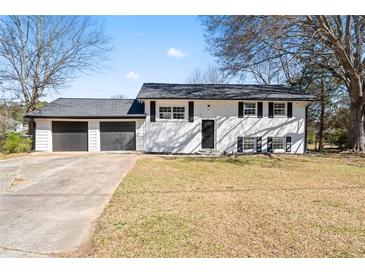 Charming two-story home featuring a two-car garage, black shutters, and a spacious front yard at 6650 Baldwin Ct, Riverdale, GA 30274