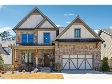 Charming two-story brick home with a covered front porch and two-car garage at 3836 Alice Ln, Suwanee, GA 30024