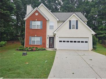 Charming two-story home with brick facade, light siding, manicured lawn, and a two-car garage at 1822 Hayden Mill Ct, Lawrenceville, GA 30043
