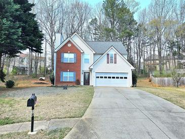 Charming two-story home with brick and siding, featuring an attached garage and mature landscaping at 1822 Hayden Mill Ct, Lawrenceville, GA 30043