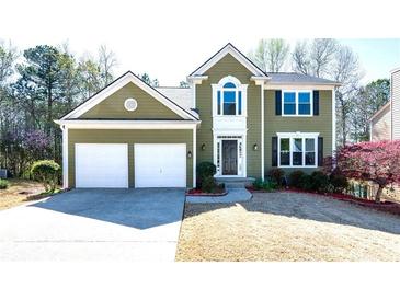 Charming two-story home featuring a two-car garage, well-manicured lawn, and classic architectural details at 3876 Toccoa Falls Dr, Duluth, GA 30097