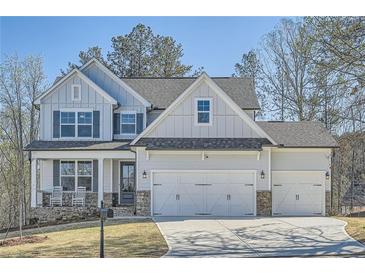 Beautiful two-story home with a three car garage, stone accents, and a charming front porch with rocking chairs at 115 Laurelwood Ln, Dallas, GA 30157