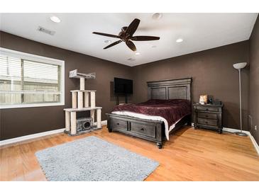 A stylish bedroom with a ceiling fan, wood floors, and a cat tree at 3501 Roswell Ne Rd # 211, Atlanta, GA 30305