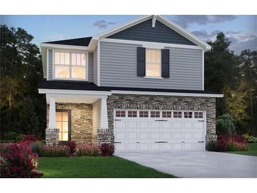 Charming two-story home featuring stone accents, a two-car garage, and a well-manicured lawn at 4825 Marjorie Dr, Cumming, GA 30041