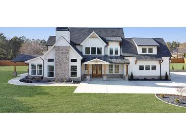 Stunning two-story modern farmhouse with a brick chimney, manicured lawn, and beautiful landscaping at 195 Hope Hollow Rd, Loganville, GA 30052