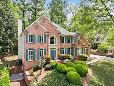 Charming brick home featuring a well-manicured lawn and teal shutters at 535 Woodbrook Way, Lawrenceville, GA 30043